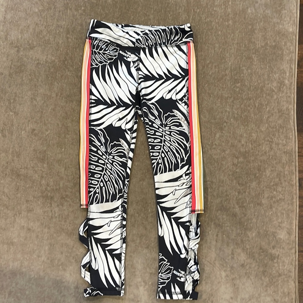 Ideology Kids activewear pants with black/white floral design and side stripe.
